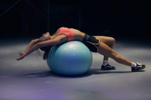Woman bending backward over a stability ball